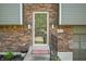Close-up of the front door with brickwork and potted plants adding charm to the entryway at 3615 Dawnwood Dr, Indianapolis, IN 46227