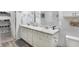 Bright bathroom featuring a double vanity with white cabinets and ample storage, adjacent to an organized walk-in closet at 400 E Charter Dr, Muncie, IN 47303
