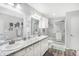 Well-lit bathroom boasts double sinks, granite counters, and a glass-enclosed shower at 400 E Charter Dr, Muncie, IN 47303