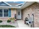 Charming front porch with decorative bench, brick facade, and well-maintained landscaping at 400 E Charter Dr, Muncie, IN 47303