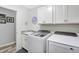 Well-lit laundry room features a modern washer and dryer, sink, and bright white cabinets for storage at 400 E Charter Dr, Muncie, IN 47303