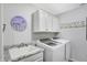 Functional laundry room with modern washer and dryer, granite countertop, and overhead cabinets at 400 E Charter Dr, Muncie, IN 47303