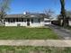 Front view of a single-story home with vinyl siding, a green lawn, and detached garage at 4120 Breton St, Indianapolis, IN 46222