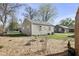 Backyard view of a cozy home featuring a well-maintained lawn, shrubs and trees offering a serene outdoor space at 413 Vasbinder Dr, Anderson, IN 46017