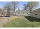 Landscaped backyard featuring a patio with seating, grassy area, and mature trees for shade and privacy at 413 Vasbinder Dr, Anderson, IN 46017