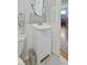 Cozy half-bathroom featuring neutral colors, a pedestal sink, and wainscotting at 413 Vasbinder Dr, Anderson, IN 46017