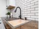 Modern kitchen sink with gooseneck faucet, wood countertop, and subway tile backsplash at 4814 Southeastern Ave, Indianapolis, IN 46203