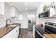 Well-lit kitchen with white cabinets, stainless steel appliances, and dark countertops at 4814 Southeastern Ave, Indianapolis, IN 46203