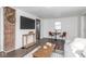 Open-concept living room with a table set for two, a modern television, and hardwood floors at 4814 Southeastern Ave, Indianapolis, IN 46203