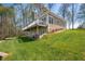 Rear exterior showcasing a deck, lower patio, walkout basement and lush backyard at 4955 N 500 W, Columbus, IN 47201
