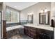 Bathroom featuring dual sinks, dark wood cabinets, granite countertops, and a soaking tub at 4955 N 500 W, Columbus, IN 47201