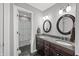 Elegant bathroom boasts a double sink vanity, granite countertops, and decorative oval mirrors at 4955 N 500 W, Columbus, IN 47201