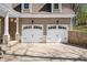 Close up of the two car garage with black hardware, white doors, and stone accents on the pillars at 4955 N 500 W, Columbus, IN 47201