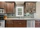 Beautiful kitchen with dark wood cabinetry, granite counters, and stone backsplash details at 4955 N 500 W, Columbus, IN 47201