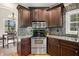 Kitchen showcasing dark cabinets, stone backsplash, and stainless steel appliances at 4955 N 500 W, Columbus, IN 47201