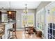 Kitchen with bar seating flows into bright dining area featuring large windows and a door to the deck at 4955 N 500 W, Columbus, IN 47201