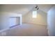 Bright attic room with a vaulted ceiling, a window for natural light, and neutral carpeting at 5135 N Kenwood Ave, Indianapolis, IN 46208