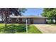 Lovely brick home featuring a well-manicured lawn and flower-adorned address post at 5444 S Holiday Dr, Columbus, IN 47203