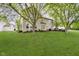 Lush backyard featuring a well-maintained lawn, mature trees, and a view of the home's exterior at 5698 Kenderly Ct, Carmel, IN 46033