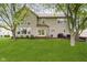 Expansive backyard showcasing the home's rear facade, a well-manicured lawn, and outdoor seating areas at 5698 Kenderly Ct, Carmel, IN 46033