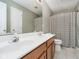Well-lit bathroom with double sinks, white countertops, a decorative mirror, and a shower with patterned curtains at 5698 Kenderly Ct, Carmel, IN 46033