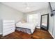 Bright bedroom with dark hardwood floors, soft white bedding, modern decor, and natural light from the window at 5698 Kenderly Ct, Carmel, IN 46033