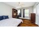 Comfortable bedroom featuring hardwood floors, a ceiling fan, a wooden desk, and natural light from the window at 5698 Kenderly Ct, Carmel, IN 46033