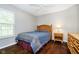 Inviting bedroom featuring a wood bed frame, dark hardwood floors, neutral walls, and ample natural light at 5698 Kenderly Ct, Carmel, IN 46033