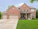 Beautiful brick two-story home with a well-manicured lawn and attached three car garage at 5698 Kenderly Ct, Carmel, IN 46033