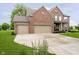 Brick two-story home features an attached three-car garage and a well-maintained lawn at 5698 Kenderly Ct, Carmel, IN 46033