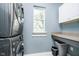 Functional laundry room with stacked washer/dryer, storage cabinets, and a built-in counter for folding at 5698 Kenderly Ct, Carmel, IN 46033