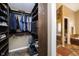 Custom walk-in closet featuring dark wood cabinets, ample shelving, and hanging space, with an adjacent bathroom at 5698 Kenderly Ct, Carmel, IN 46033
