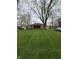 Charming brick home features a covered front porch and a beautifully manicured lawn, perfect for outdoor enjoyment at 5774 N Ewing St, Indianapolis, IN 46220