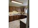 Kitchen with dark wooden cabinets, stainless steel sink and laminate countertops at 5774 N Ewing St, Indianapolis, IN 46220
