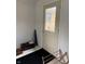 Cream colored mud room provides an entrance/exit door to the outside with black mat at 5774 N Ewing St, Indianapolis, IN 46220