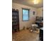 This office space includes a bookcase filled with movies and a window at 5774 N Ewing St, Indianapolis, IN 46220