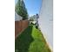 Side yard with well-maintained grass, privacy fence, and a glimpse of surrounding neighborhood homes at 5912 Accent Dr, Indianapolis, IN 46221