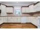 Traditional kitchen with light cabinets, tile backsplash, modern appliances, and wood flooring at 6345 Canak Dr, Avon, IN 46123