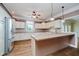 Bright eat-in kitchen boasting white cabinets, wood floors and an island with counter seating at 6345 Canak Dr, Avon, IN 46123