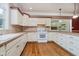 Well-lit kitchen features light cabinets, tiled countertops, and wood floors; view into the adjacent living room at 6345 Canak Dr, Avon, IN 46123