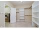 Bright walk-in closet featuring custom shelving and convenient laundry room access with modern washer and dryer units at 6345 Canak Dr, Avon, IN 46123