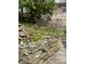 Landscaped backyard with stone retaining wall, pond, and an array of blooming flowers adding beauty to the scenery at 7030 Central Ave, Indianapolis, IN 46220