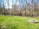 Expansive backyard features lush green grass and a stone fire pit, ideal for outdoor enjoyment and gatherings at 7150 Pheasant Ridge Dr, Indianapolis, IN 46237
