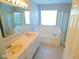 Bright bathroom with double sink vanity, large tub, and a window at 7150 Pheasant Ridge Dr, Indianapolis, IN 46237