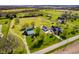 Scenic aerial view of the property, featuring a home, outbuildings, well-kept lawns, and surrounding farmland at 7371 E 100 N, Whitestown, IN 46075