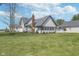 Spacious backyard showcasing a well-maintained lawn, mature trees, and the rear facade of the home at 7371 E 100 N, Whitestown, IN 46075