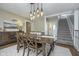 An elegant dining room with a rustic wood table, chairs, chandelier, and built-in storage at 7371 E 100 N, Whitestown, IN 46075