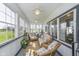 Bright sunroom with multiple windows, ceiling fans, neutral furniture, and potted plants at 7371 E 100 N, Whitestown, IN 46075