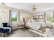 Serene bedroom featuring a plush bed, accent chair, and ample natural light from two windows at 7440 Graham Rd, Indianapolis, IN 46250