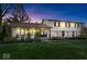 Charming two-story home with a well-manicured lawn, beautiful landscaping and brick accents at dusk at 7440 Graham Rd, Indianapolis, IN 46250
